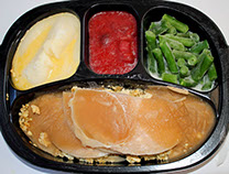 picture of a turkey tv dinner with vegetables, mashed potatos, and desert